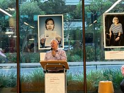 Uncle Widdy stands speaking at a lectern.