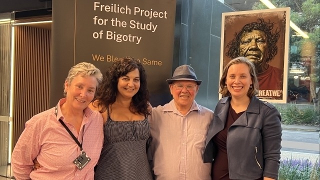 Prof. Bronwyn Parry, Liz Deep-Jones, Uncle Widdy, and Dr Melissa Lovell stand in front of a Frelich Project banner.
